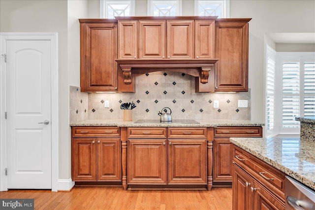 kitchen with light wood-type flooring, black electric stovetop, and brown cabinetry