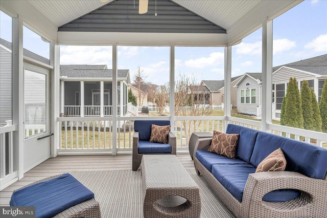 sunroom / solarium featuring lofted ceiling and a residential view