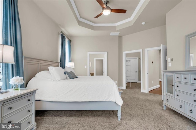 bedroom with crown molding, a raised ceiling, light carpet, ceiling fan, and baseboards