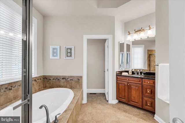 full bath with a shower, plenty of natural light, vanity, and a bath