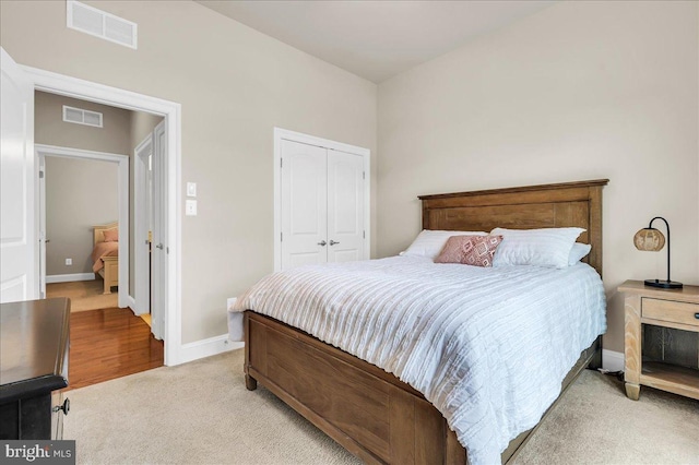 bedroom featuring light carpet, baseboards, visible vents, and a closet