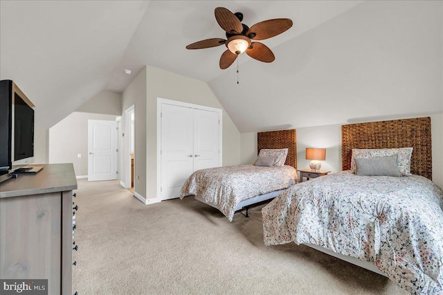 bedroom with a closet, light colored carpet, vaulted ceiling, ceiling fan, and baseboards