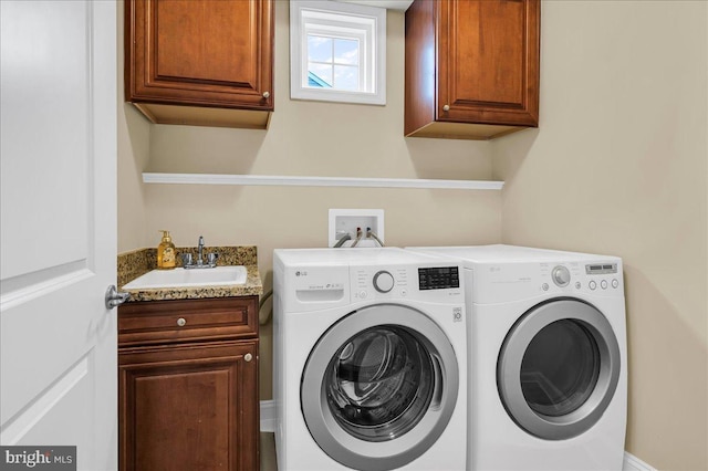 laundry room with a sink, cabinet space, and washer and dryer