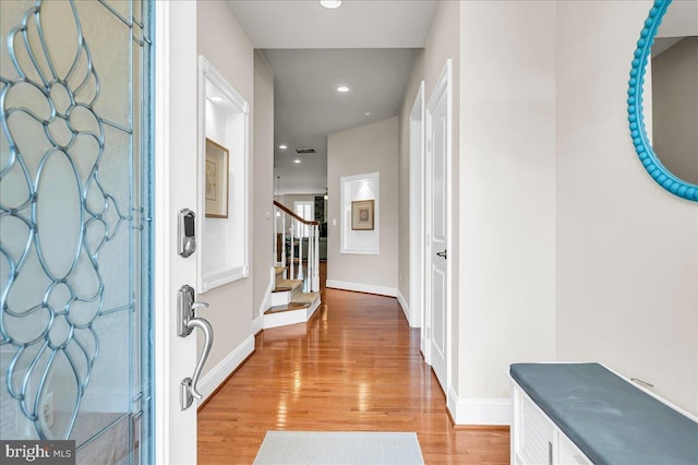 foyer entrance with baseboards, visible vents, light wood-style flooring, stairs, and recessed lighting