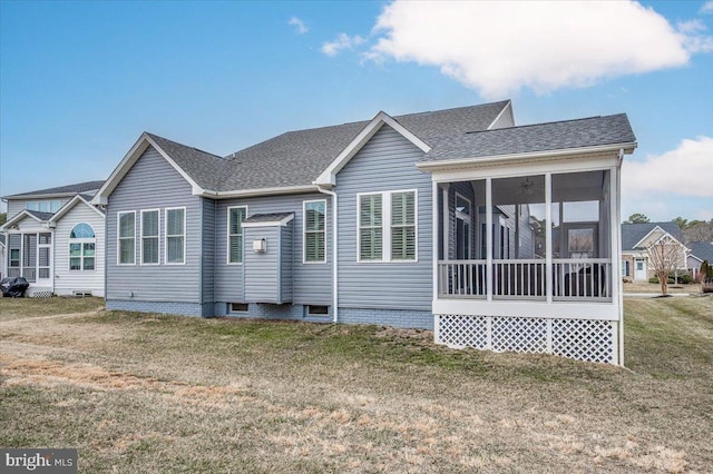 back of house with a sunroom, roof with shingles, and a yard