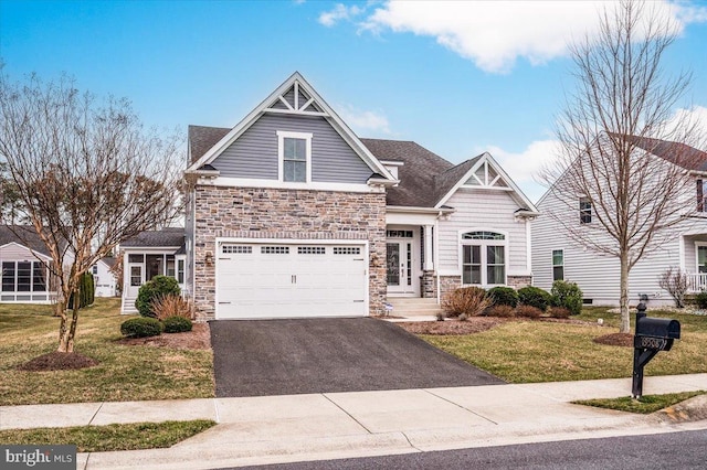 craftsman-style home featuring an attached garage, a shingled roof, stone siding, driveway, and a front lawn