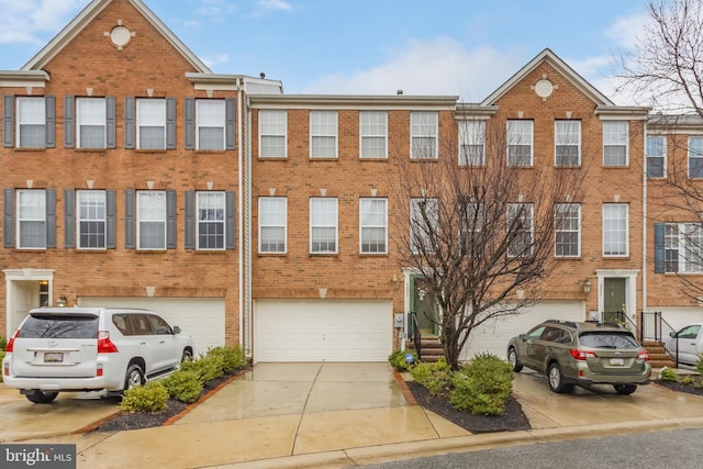 townhome / multi-family property with brick siding, driveway, and an attached garage