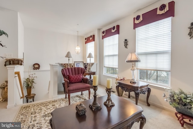 living area with carpet floors and an upstairs landing