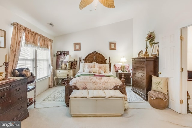 carpeted bedroom featuring lofted ceiling, ceiling fan, and visible vents