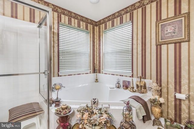 bathroom featuring a stall shower, a garden tub, and wallpapered walls