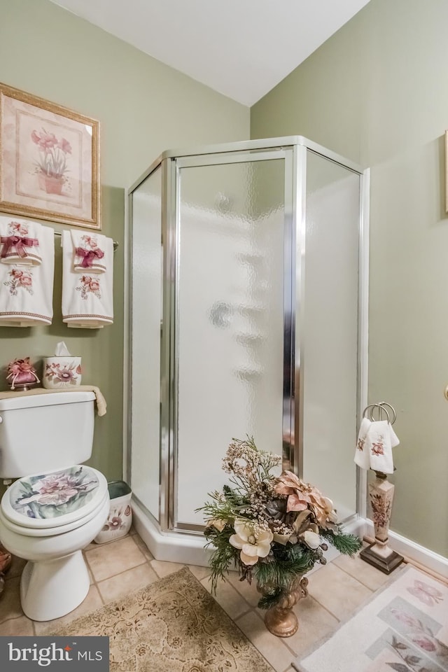 bathroom with lofted ceiling, tile patterned flooring, toilet, and a shower stall