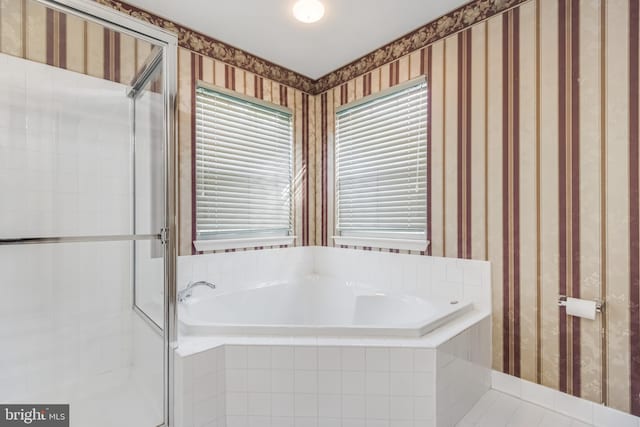 bathroom featuring wallpapered walls, a shower stall, and a bath
