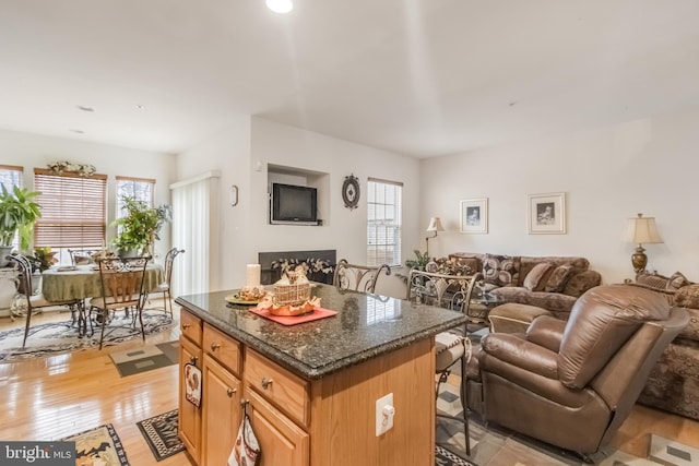 kitchen featuring light wood finished floors, plenty of natural light, a kitchen island, and open floor plan