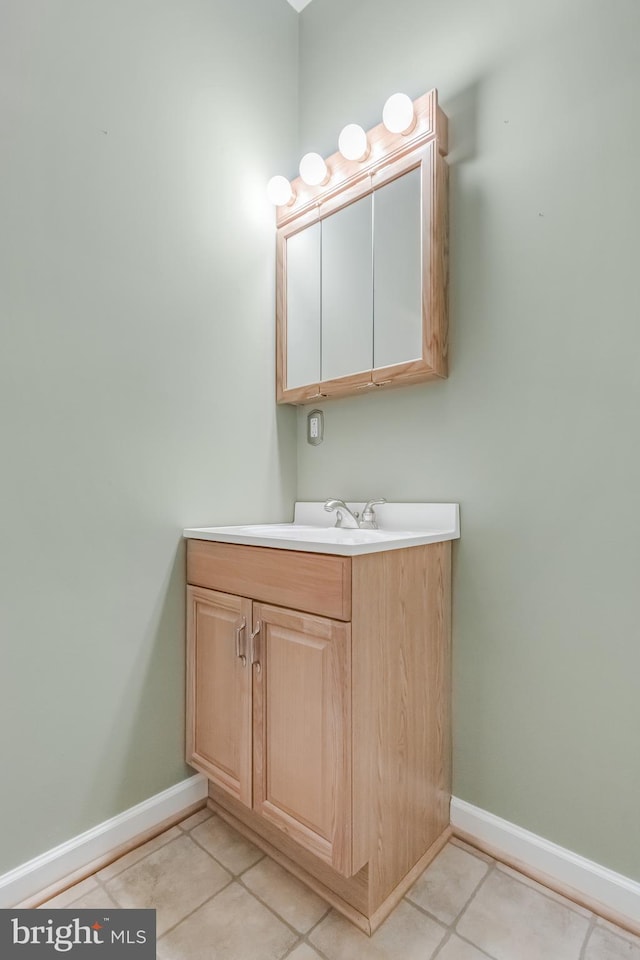 bathroom featuring baseboards, tile patterned flooring, and vanity