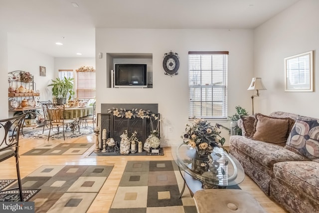 living room with a fireplace with flush hearth, wood finished floors, and recessed lighting