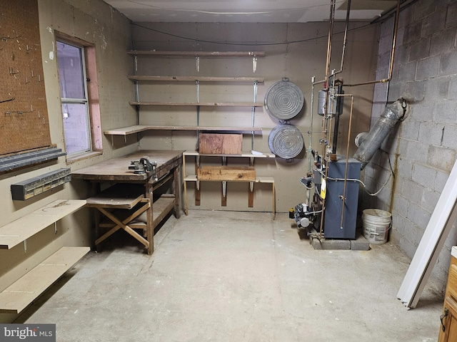 unfinished basement with a workshop area and concrete block wall