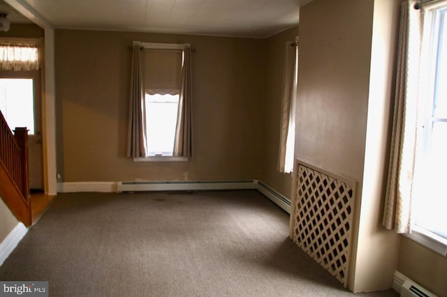 empty room featuring stairway, baseboards, a baseboard heating unit, and carpet