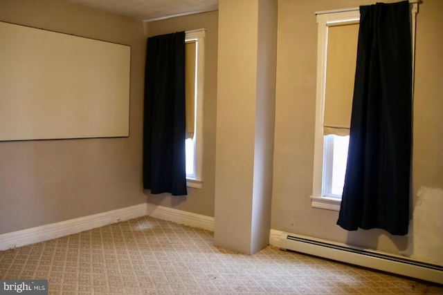 empty room featuring a baseboard radiator, baseboards, and carpet