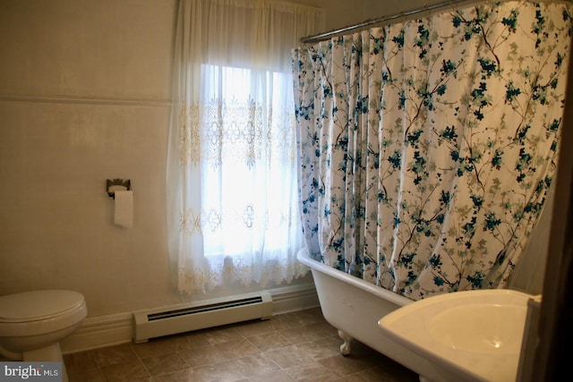 full bathroom featuring a baseboard heating unit, a healthy amount of sunlight, a tub, and tile patterned flooring