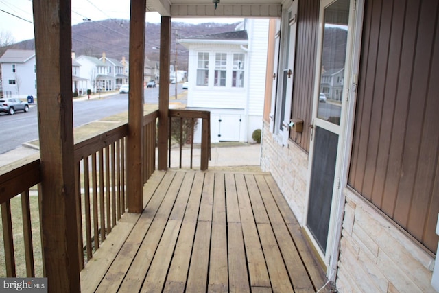 wooden terrace with covered porch and a residential view