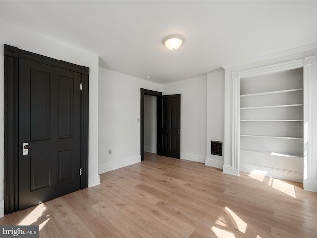 interior space featuring light wood-style flooring, visible vents, and baseboards