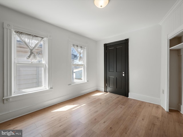 unfurnished bedroom featuring light wood finished floors and baseboards