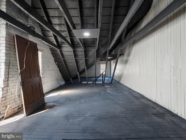 basement with hardwood / wood-style flooring and brick wall