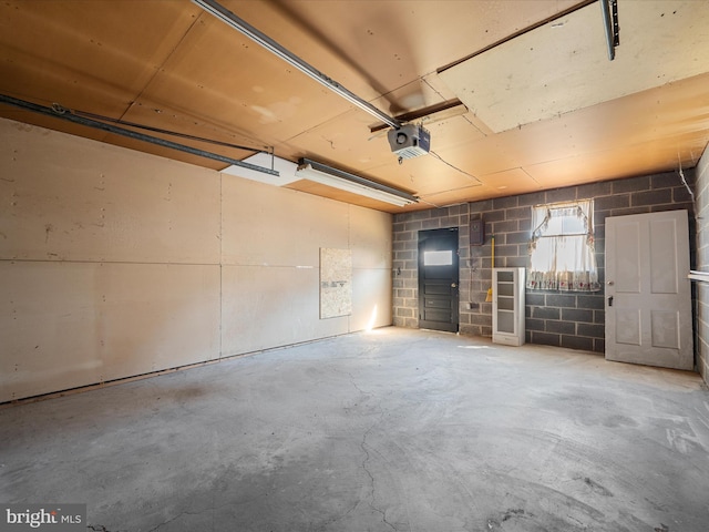 garage with concrete block wall and a garage door opener