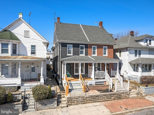 view of front of property featuring brick siding, a porch, stairs, and roof with shingles