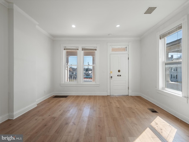 foyer with visible vents, crown molding, light wood-type flooring, and baseboards