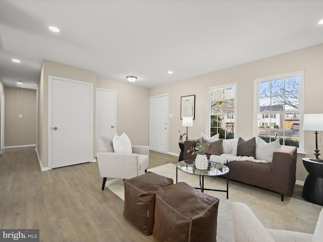 living room featuring light wood-style flooring, recessed lighting, and baseboards