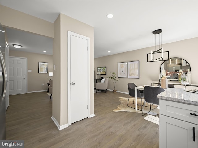 kitchen featuring recessed lighting, baseboards, light stone countertops, and light wood-style flooring