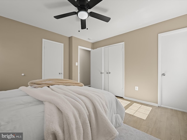 bedroom featuring baseboards, ceiling fan, and light wood finished floors