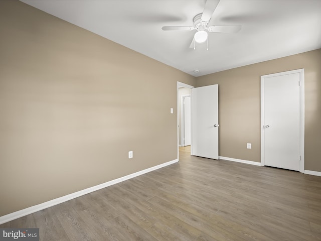 unfurnished bedroom featuring ceiling fan, baseboards, and wood finished floors