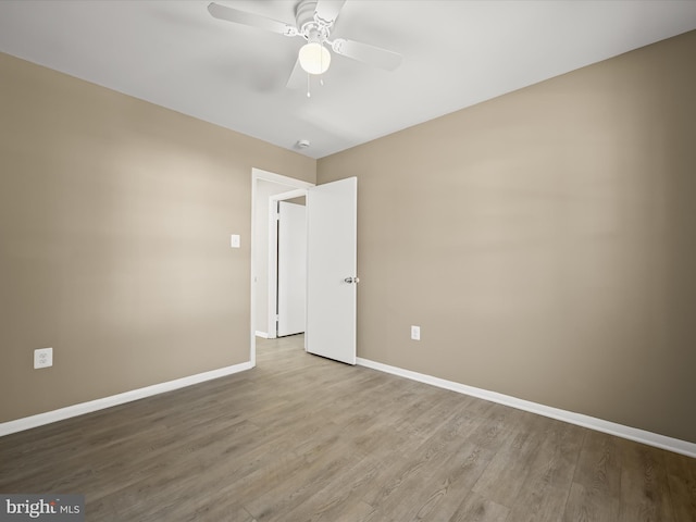 empty room featuring a ceiling fan, wood finished floors, and baseboards