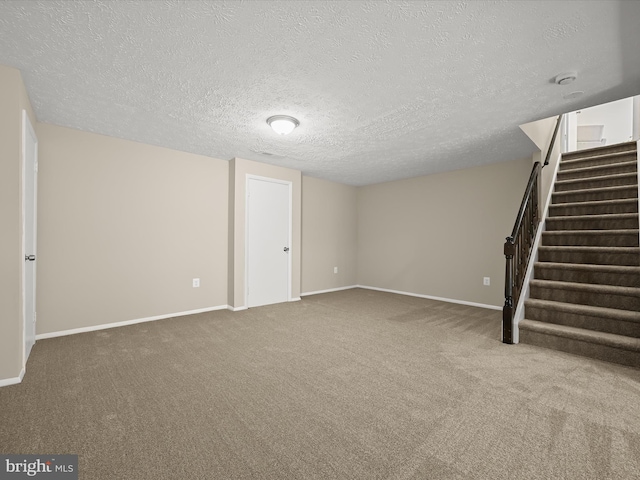 below grade area featuring stairway, carpet, baseboards, and a textured ceiling