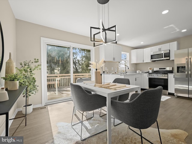 dining space with an inviting chandelier, recessed lighting, light wood-style floors, and visible vents