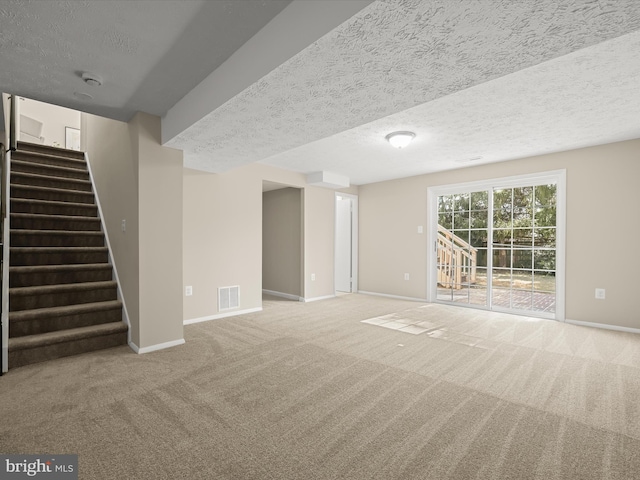 interior space featuring baseboards, visible vents, stairs, a textured ceiling, and carpet flooring