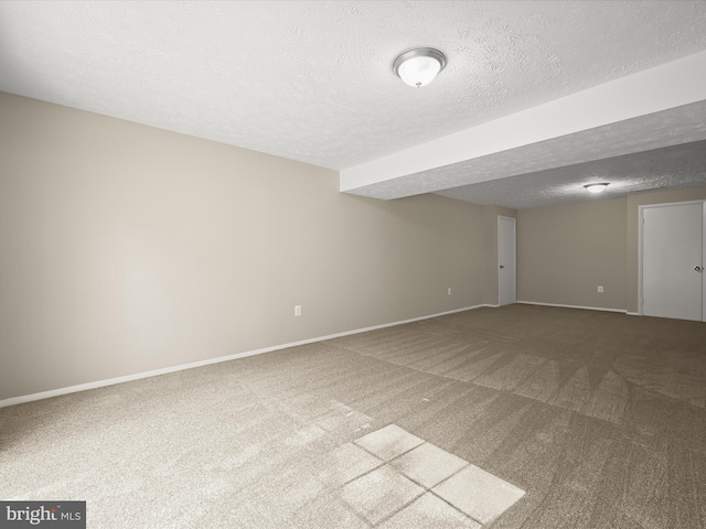 carpeted spare room featuring baseboards and a textured ceiling