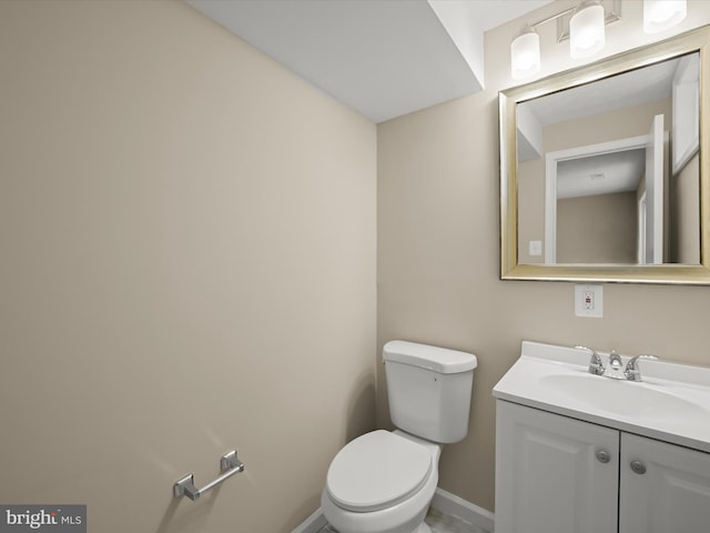 bathroom with vanity, toilet, and baseboards