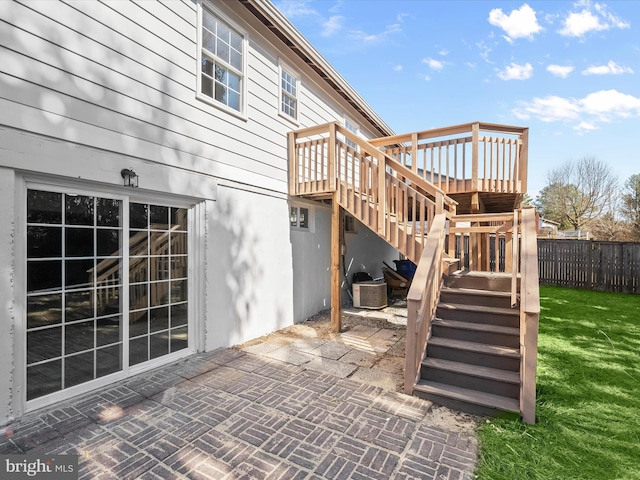 view of patio featuring a wooden deck, stairs, and fence