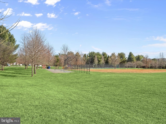 view of home's community with a yard and fence