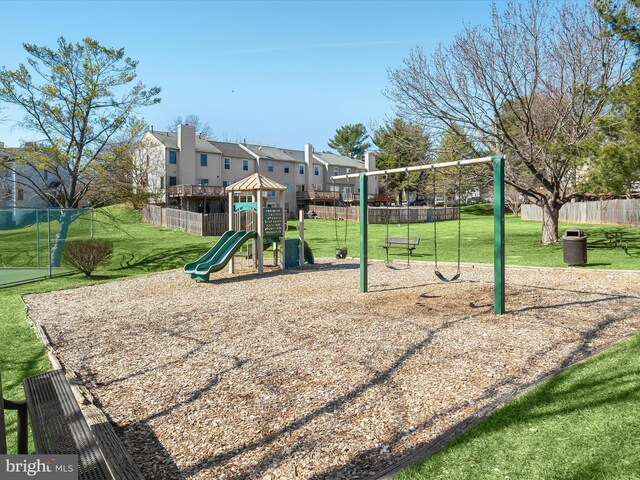 community jungle gym featuring a yard, fence, and a residential view