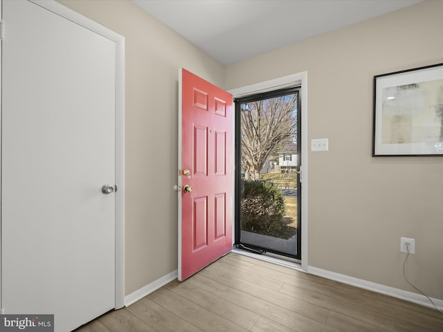 foyer entrance with light wood finished floors and baseboards