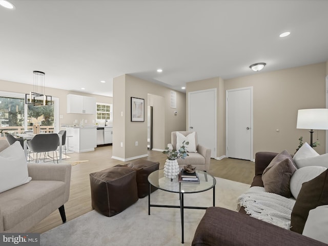 living area with recessed lighting, baseboards, and light wood finished floors