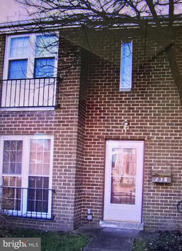 property entrance featuring brick siding