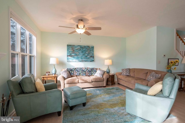 living area featuring stairway, wood finished floors, and a ceiling fan