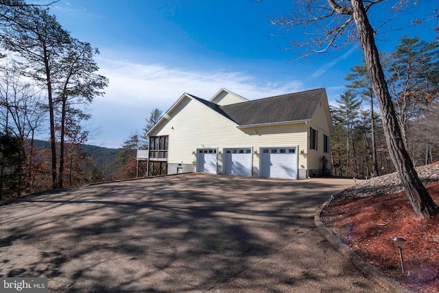 view of side of home with aphalt driveway