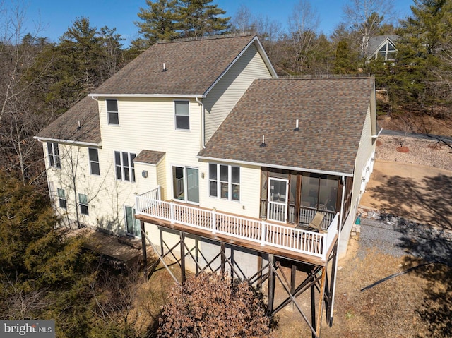 back of house with a shingled roof and a deck