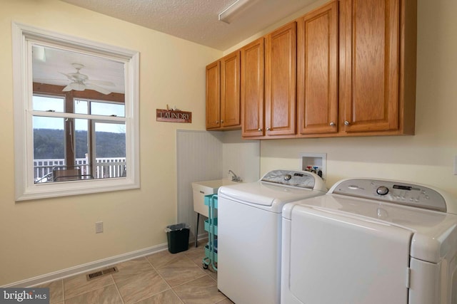 clothes washing area featuring ceiling fan, a textured ceiling, separate washer and dryer, visible vents, and cabinet space